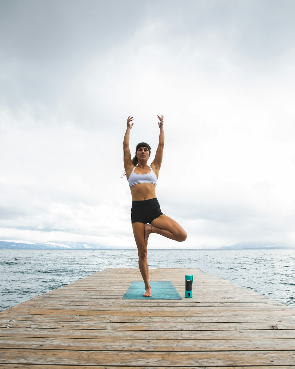 Eine Frau, die eine Yoga-Pose auf einem Dock macht