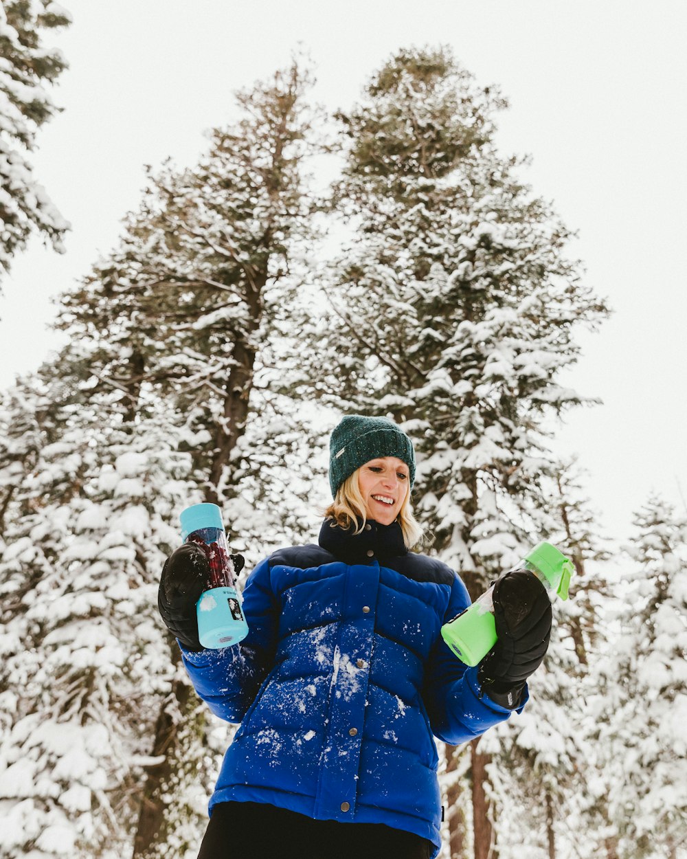 a woman standing in the snow with her hands in the air