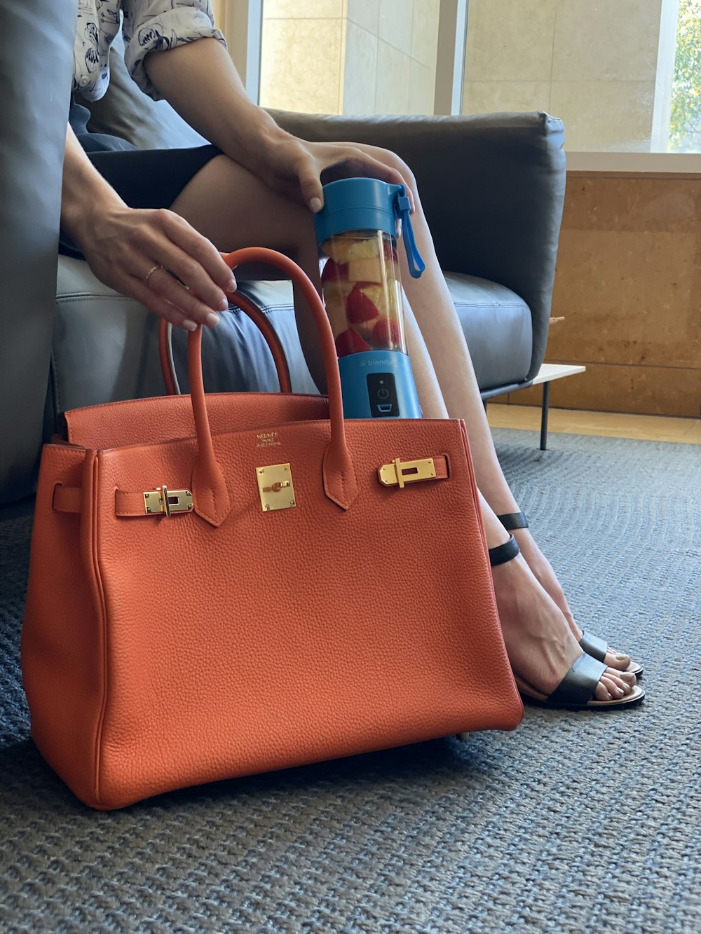 a woman sitting on a couch holding a purse