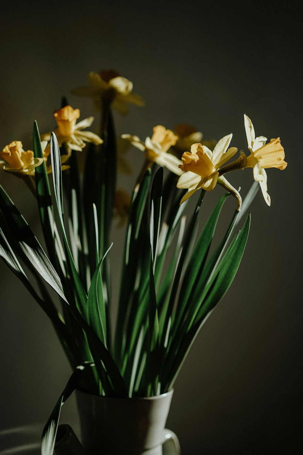 a vase filled with yellow flowers on top of a table