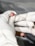 A gloved hand is holding a small lancet near a person's fingertip, with a drop of blood visible on the finger. The focus is on the finger prick procedure.
