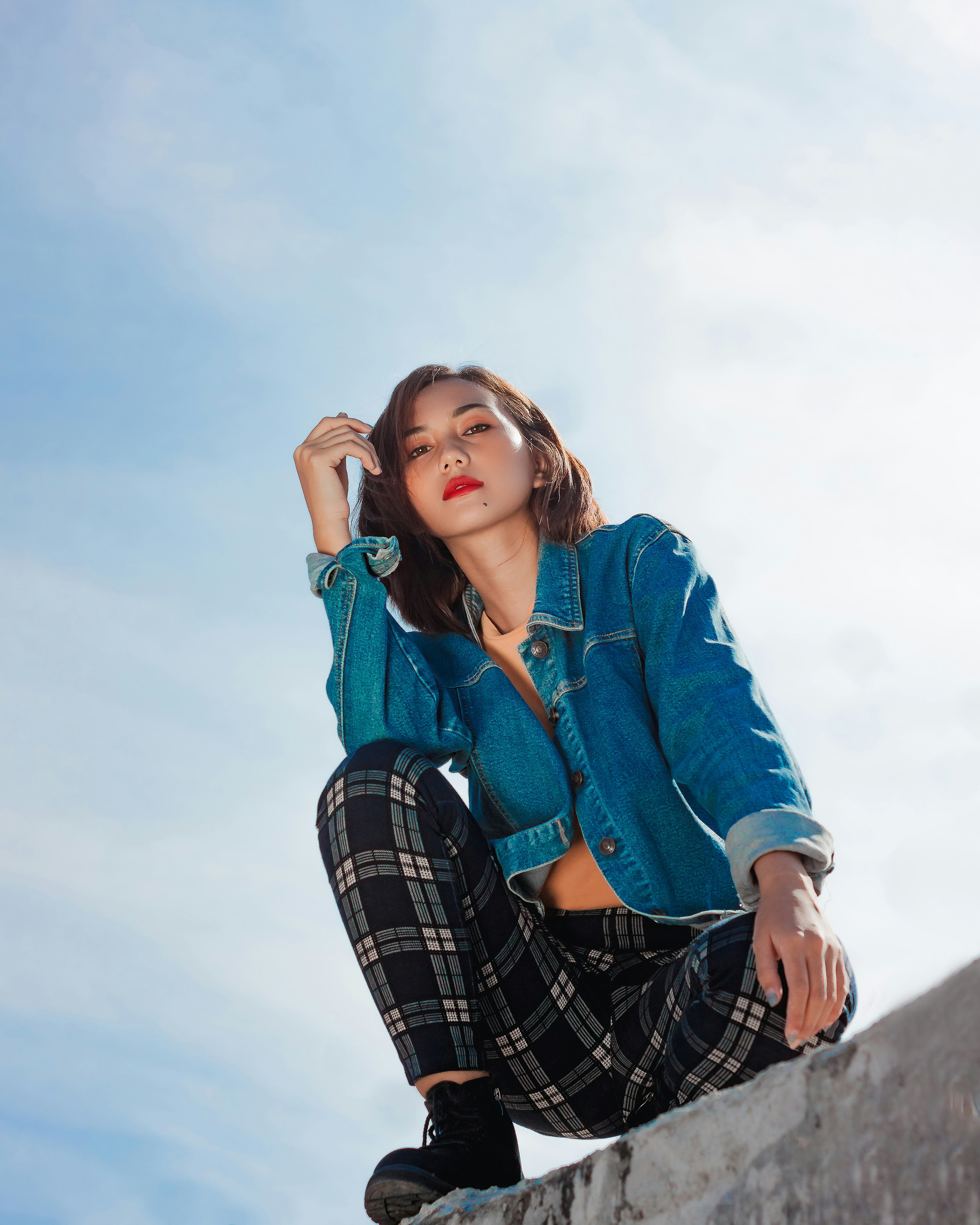 woman in blue denim jacket and black and white plaid skirt