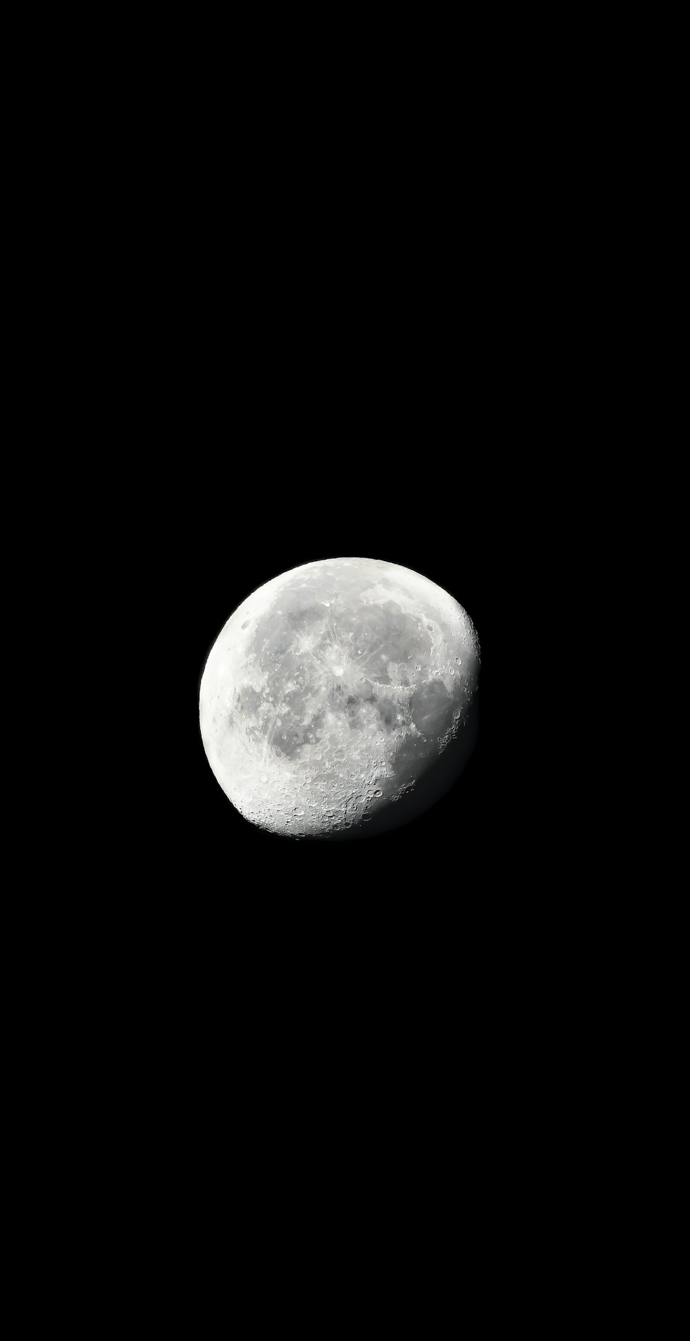 Une pleine lune est vue dans le ciel sombre