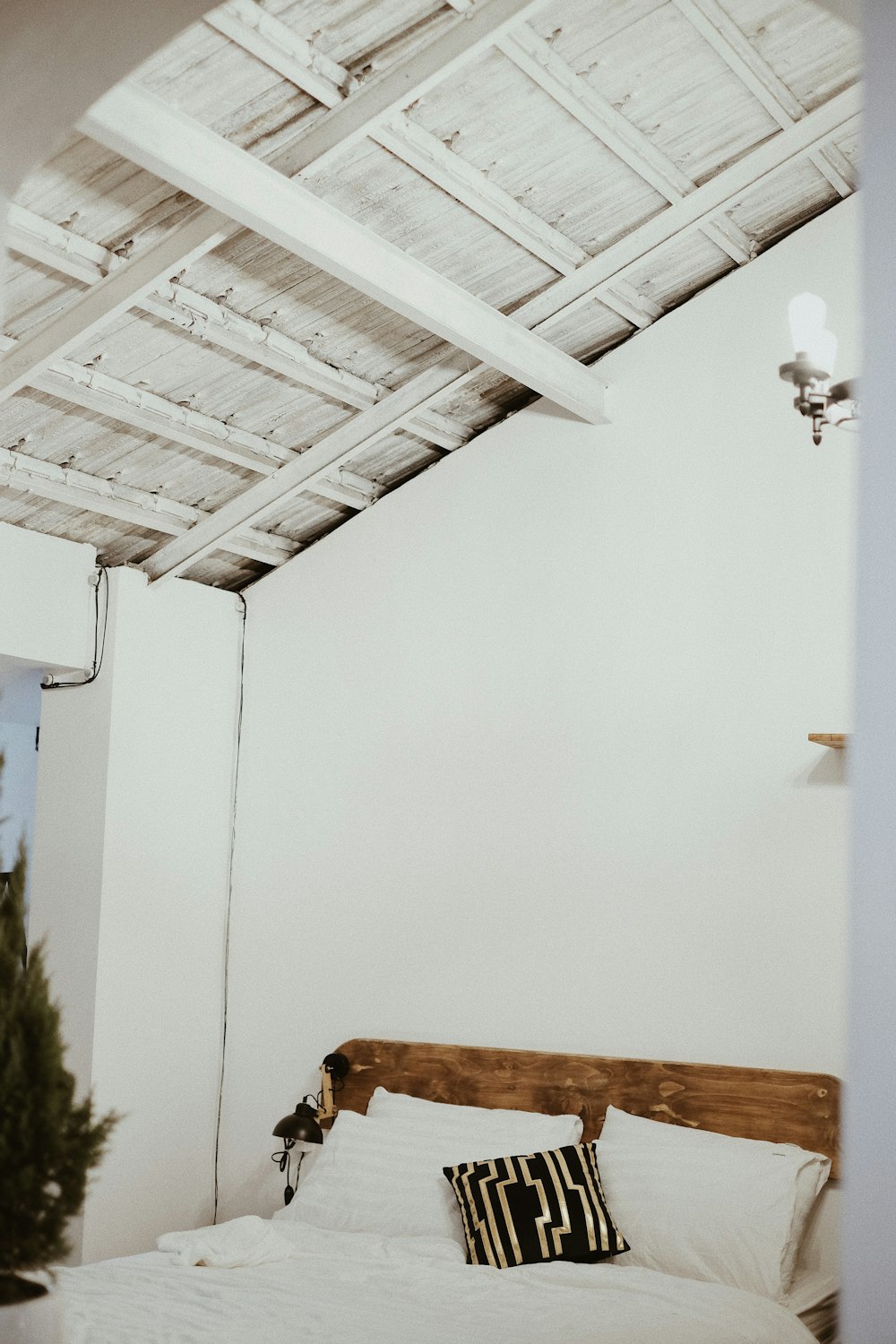 a bed with a white comforter and a wooden headboard