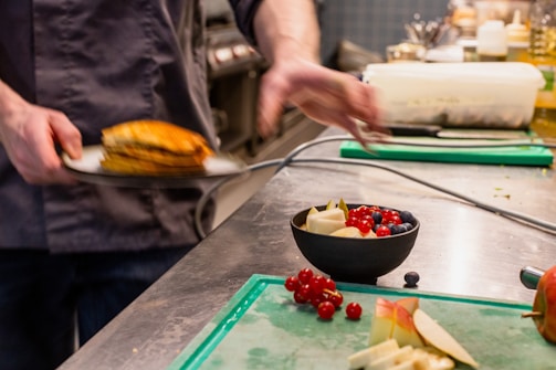 A chef plating a colorful, hearty dish in the bustling kitchen.