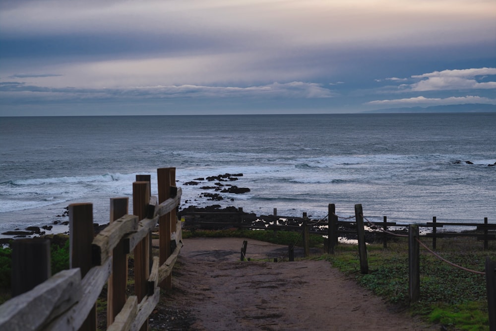 brown wooden fence on seashore during daytime