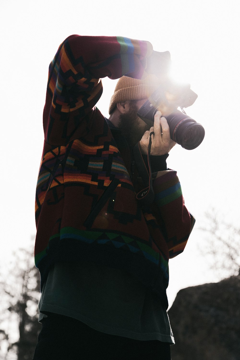 man in black and orange jacket holding white light