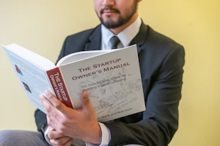 a man in a suit is reading a book