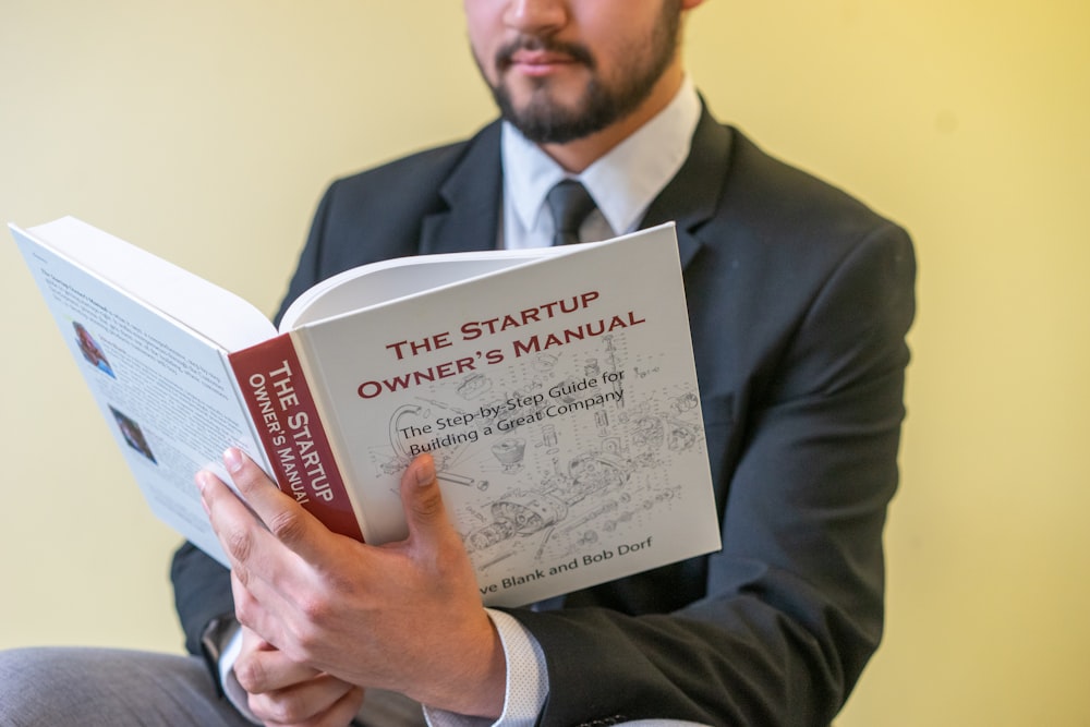 a man in a suit is reading a book