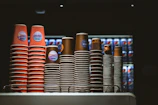 A café setting with pacaron disposable cups and lids on a counter.