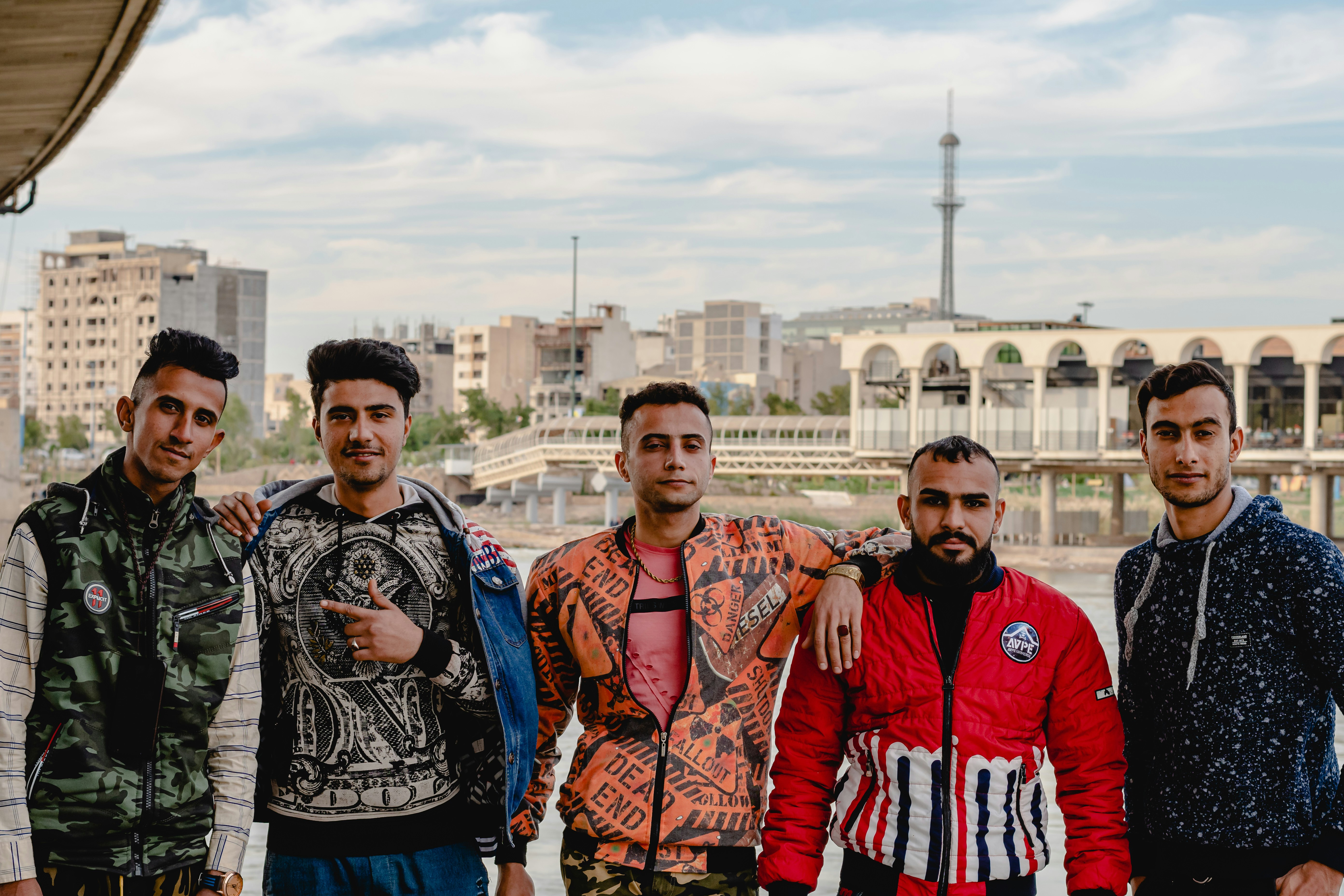 3 men standing near brown concrete building during daytime