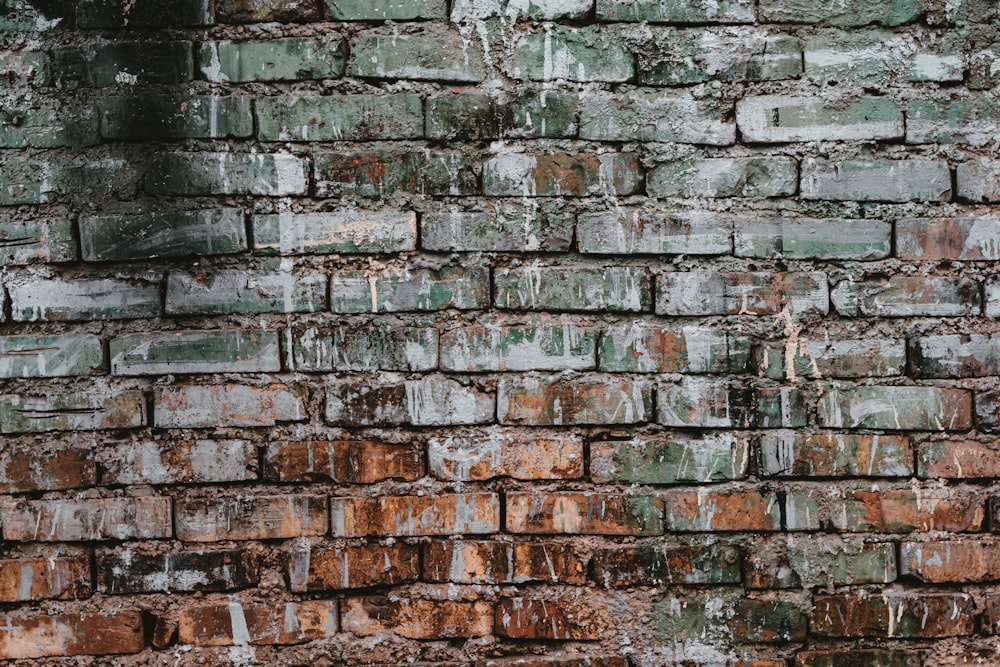 an old brick wall with peeling paint on it