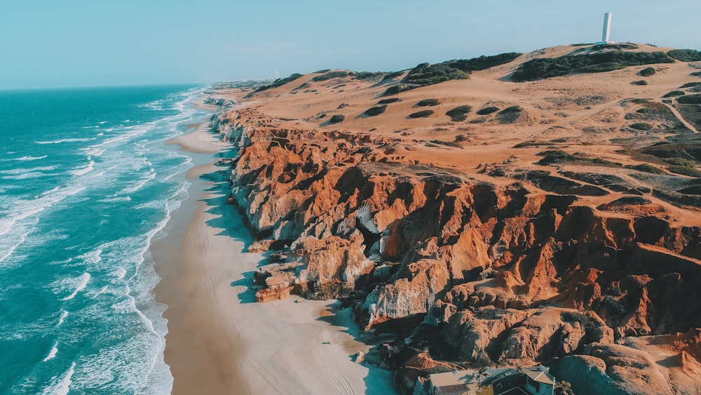 brown rock formation near body of water during daytime