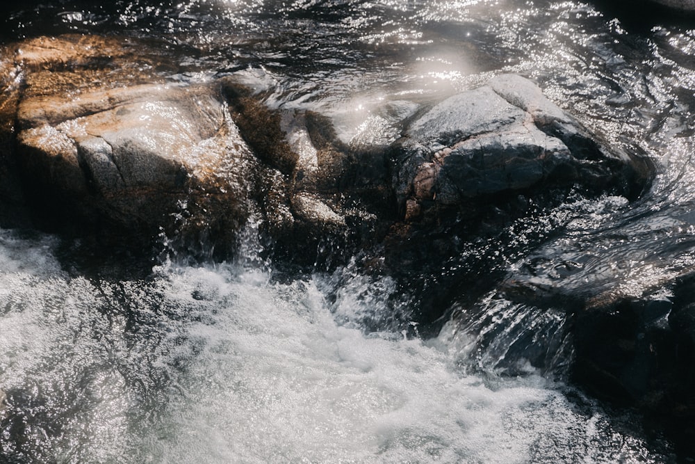 water falls on rocky shore during daytime