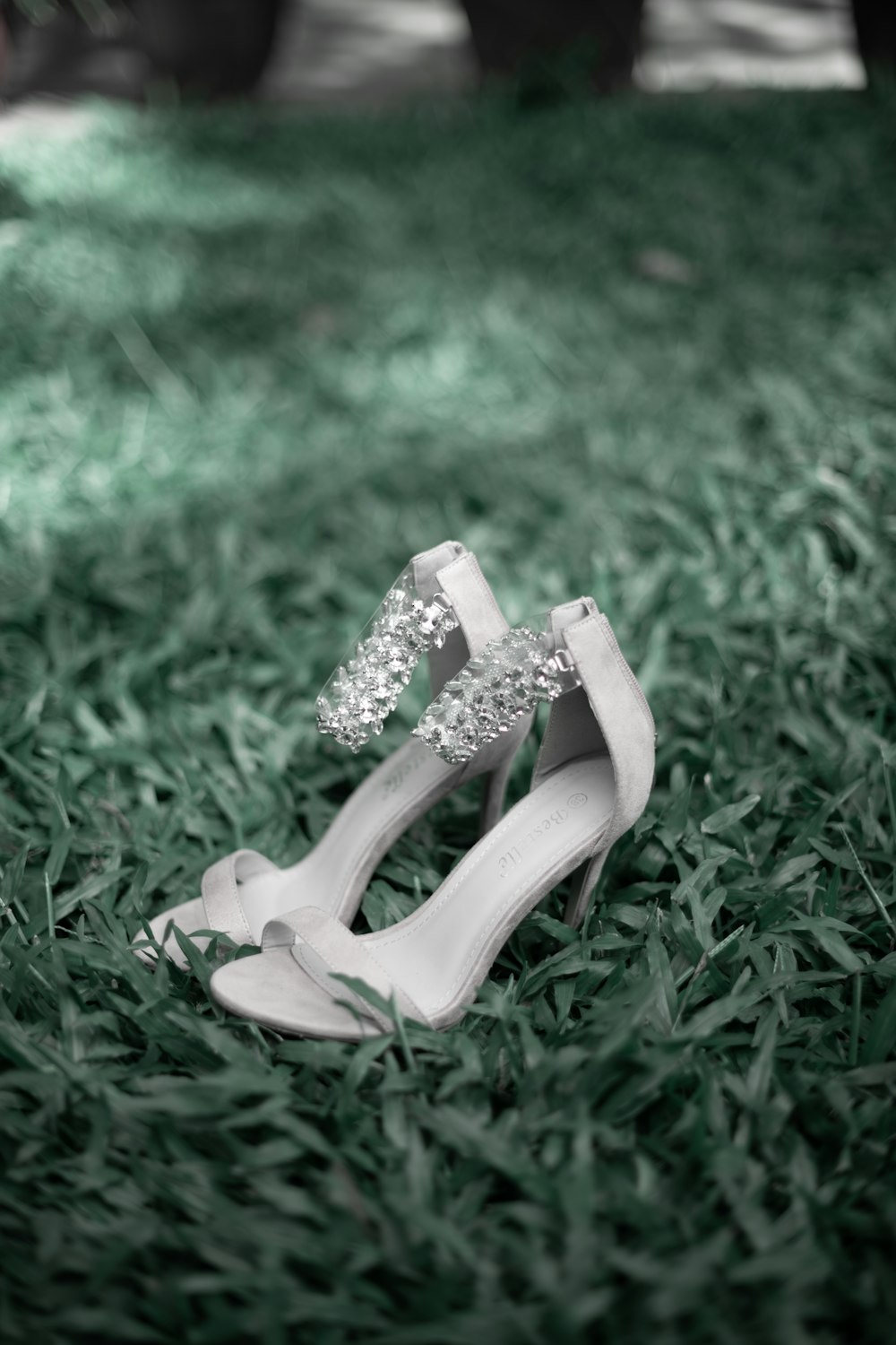 white peep toe sandals on green grass