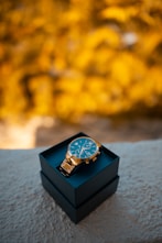 black and gold analog watch on black box