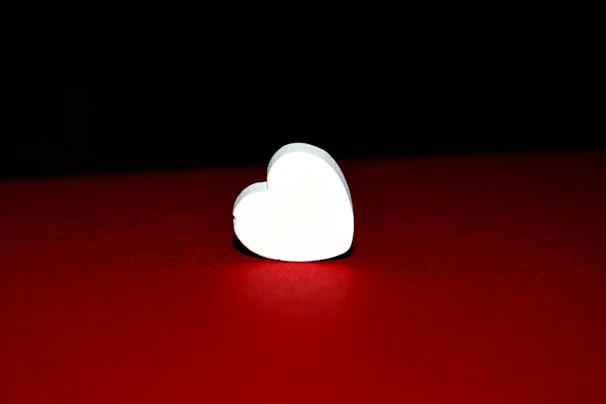 Minimalist white heart icon symbolizing premium comfort on an ivory backdrop.