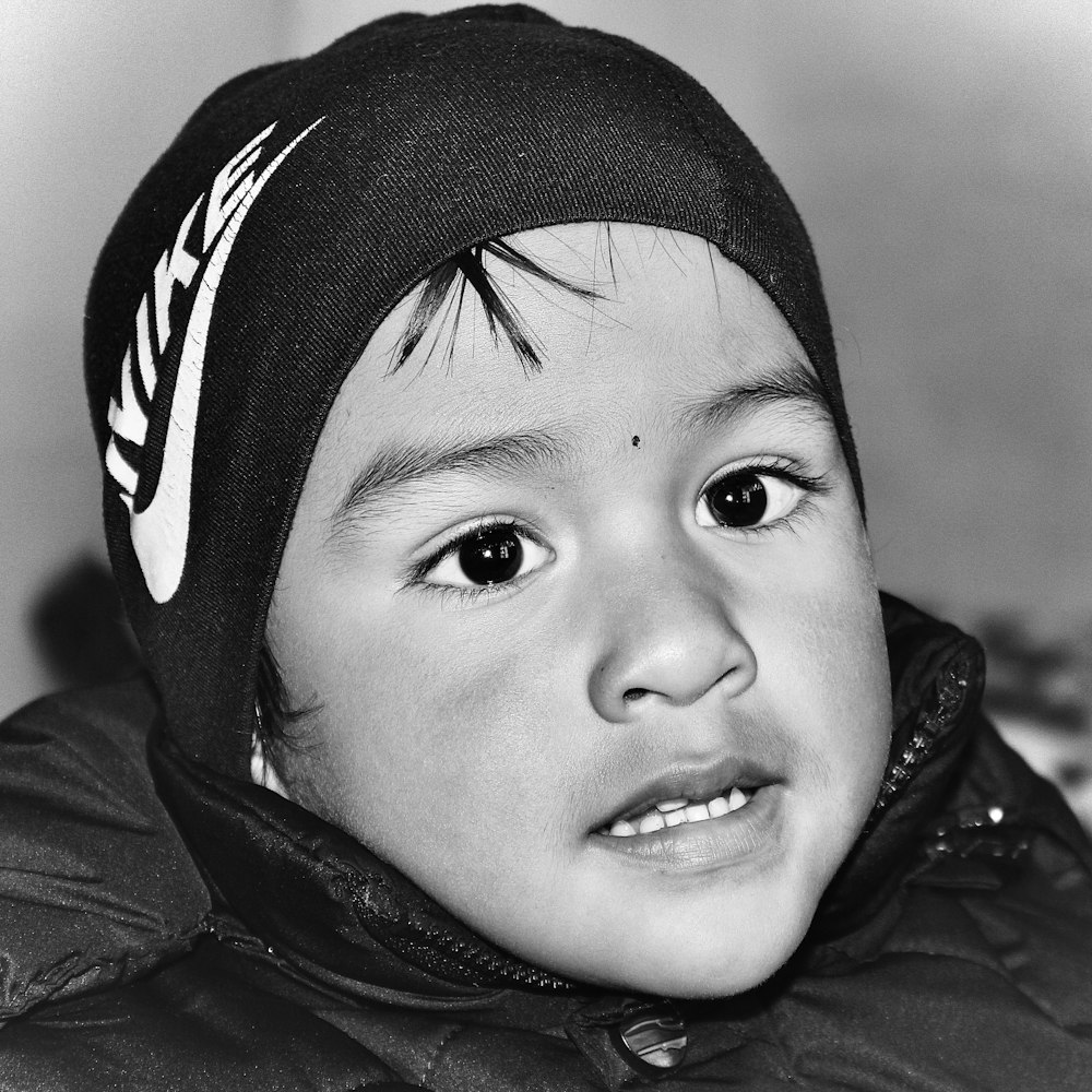 grayscale photo of child wearing knit cap