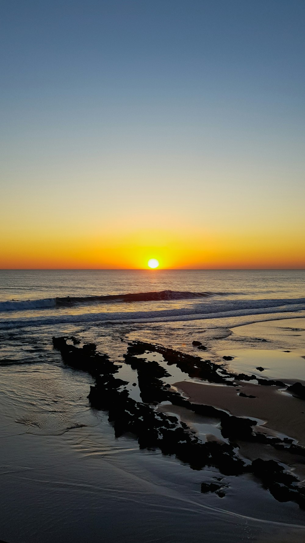 sea waves crashing on shore during sunset