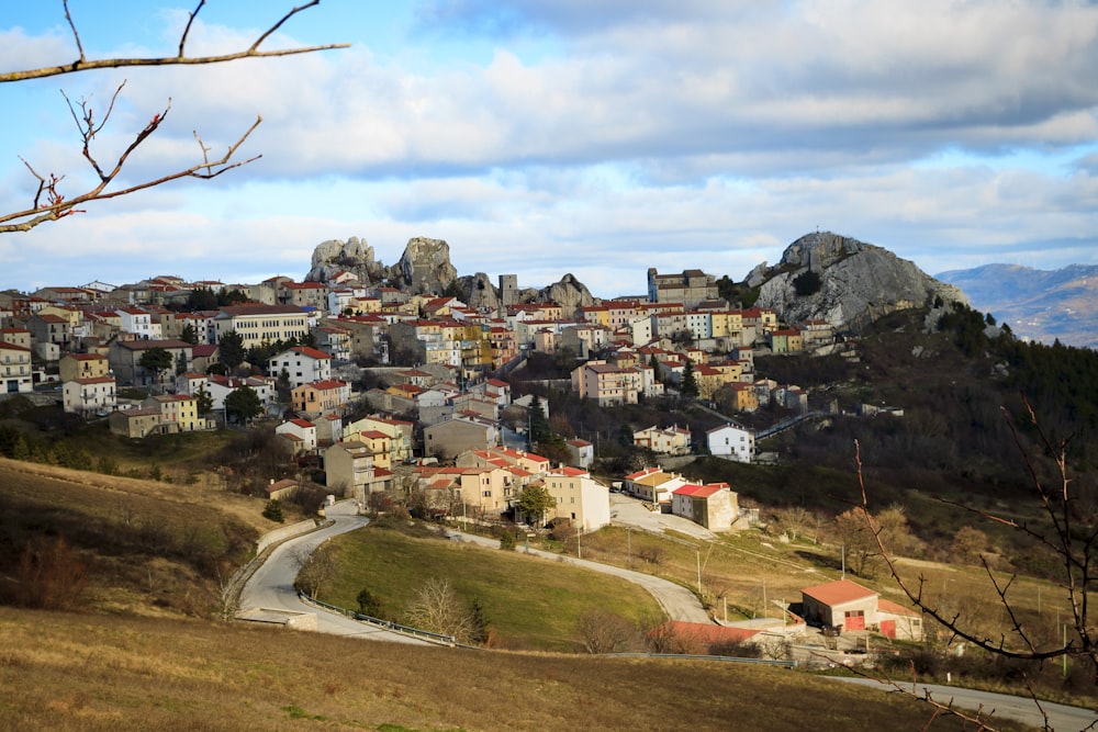 Maisons en béton brun et blanc sur un champ d’herbe verte sous des nuages blancs pendant la journée