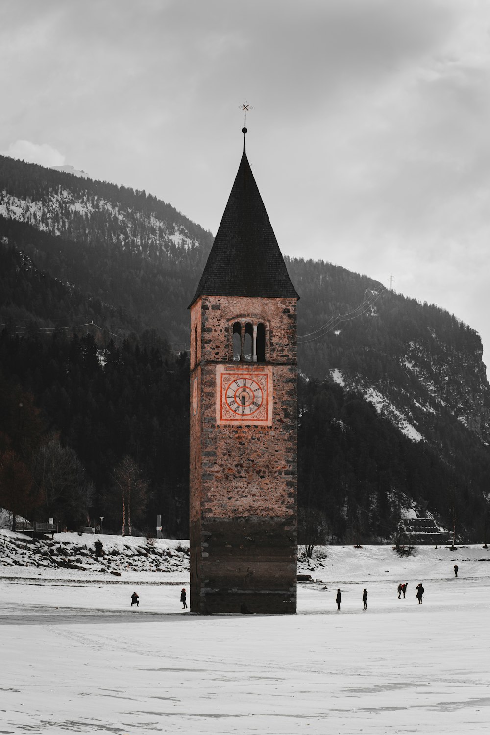 a clock tower in the middle of a snowy field