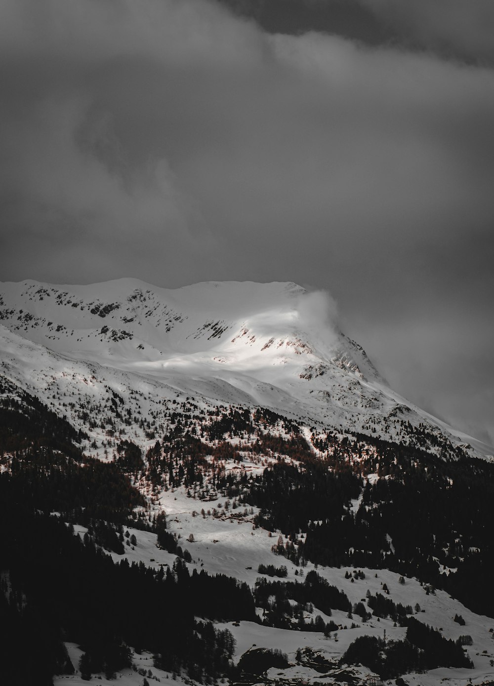 snow covered mountain under cloudy sky