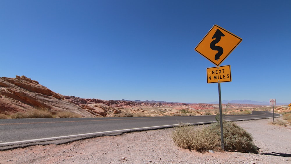 no smoking sign on gray asphalt road during daytime