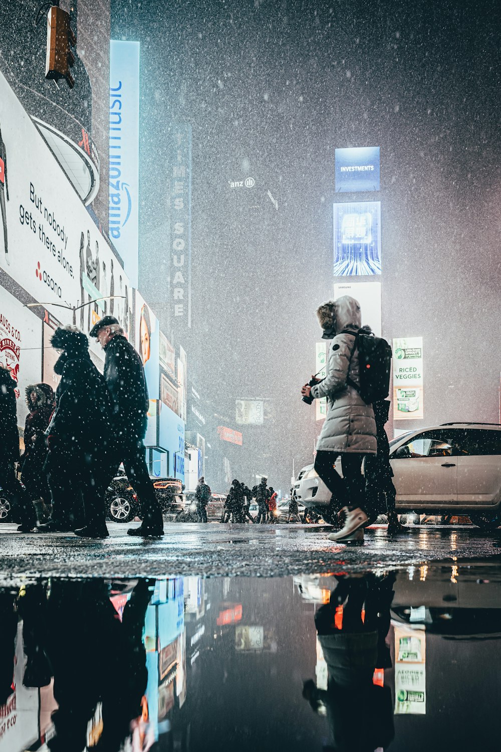 a group of people crossing a street in the rain