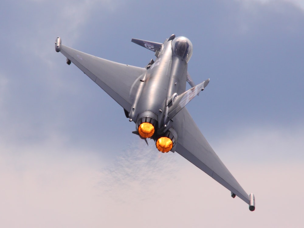 gray jet plane in mid air during daytime