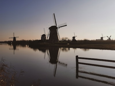 A serene view of the Zaanse Schans windmills at sunset with soft golden light.