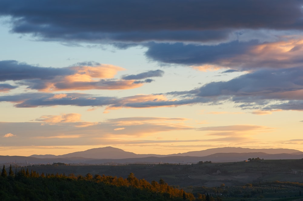 the sun is setting over the mountains in the distance