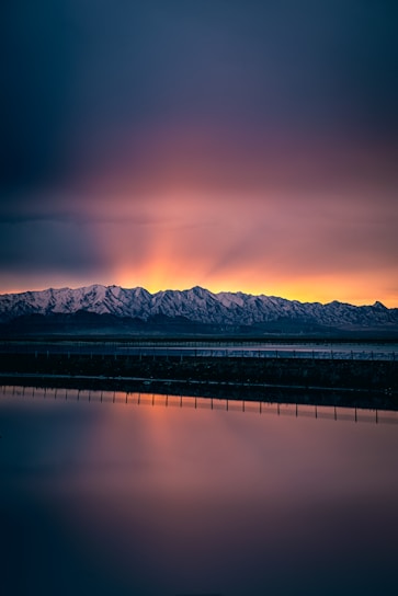 a large body of water with mountains in the background