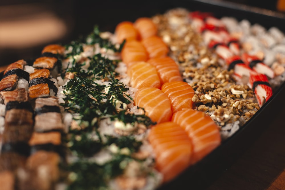 sliced carrots and green vegetable on black tray