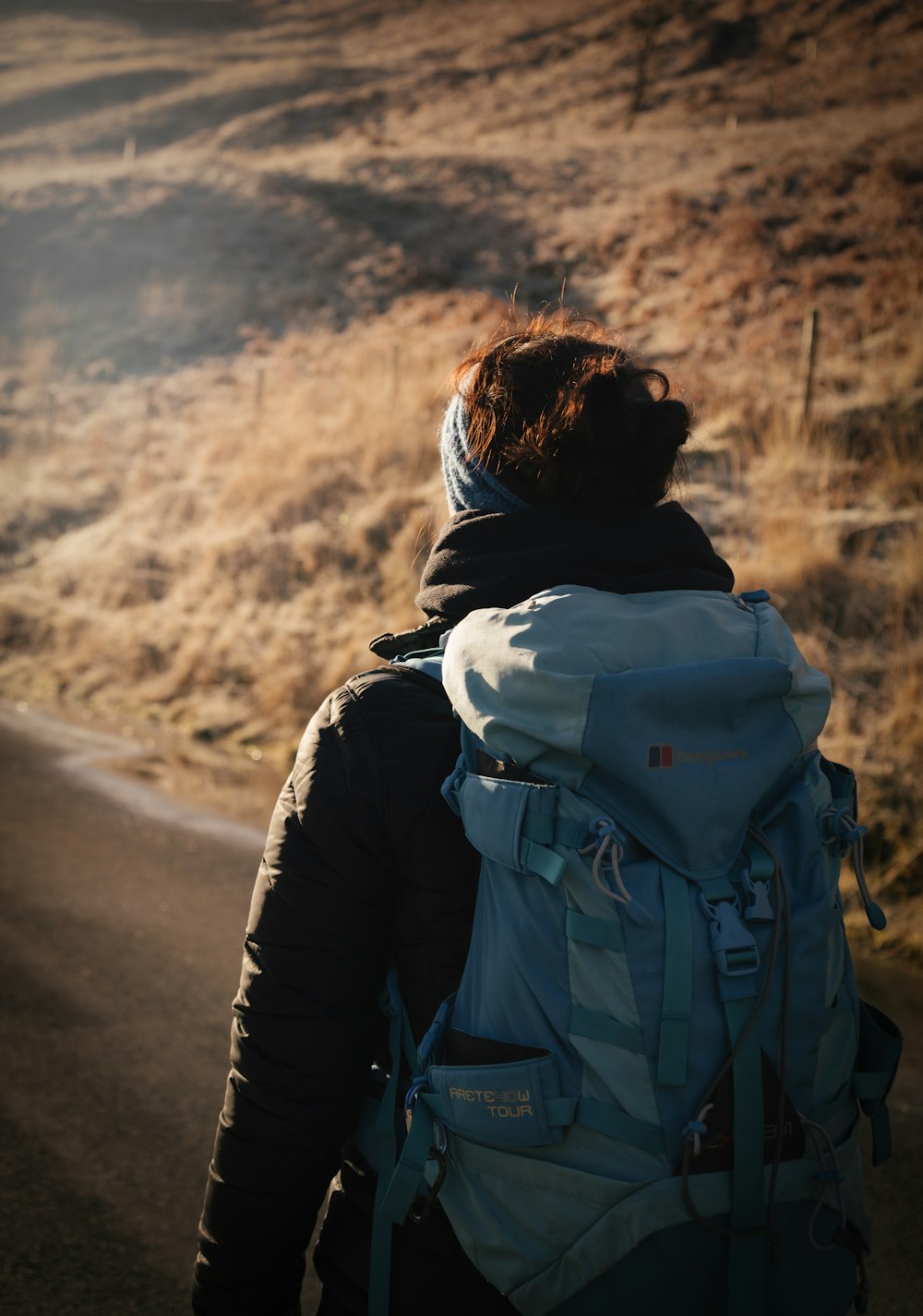 man in black jacket and gray backpack walking on road during daytime