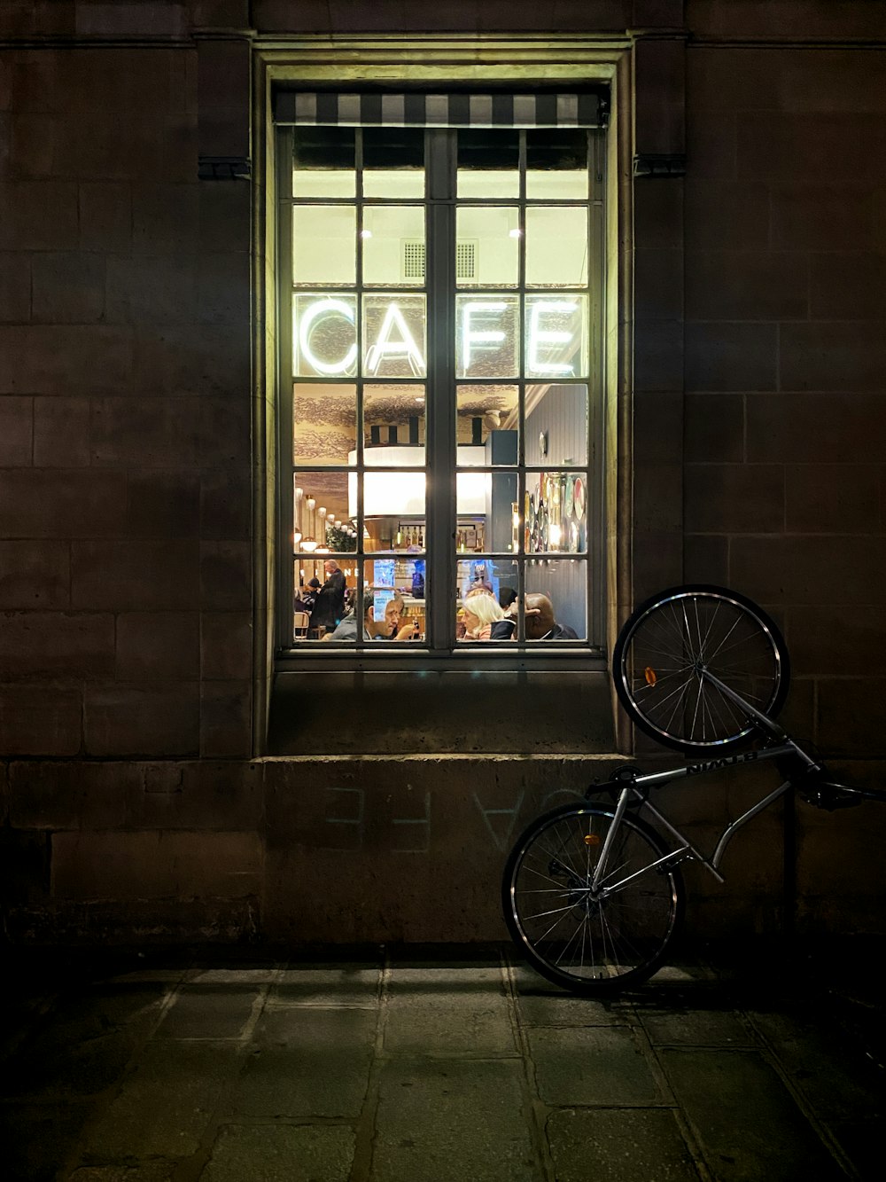 black bicycle parked beside glass window