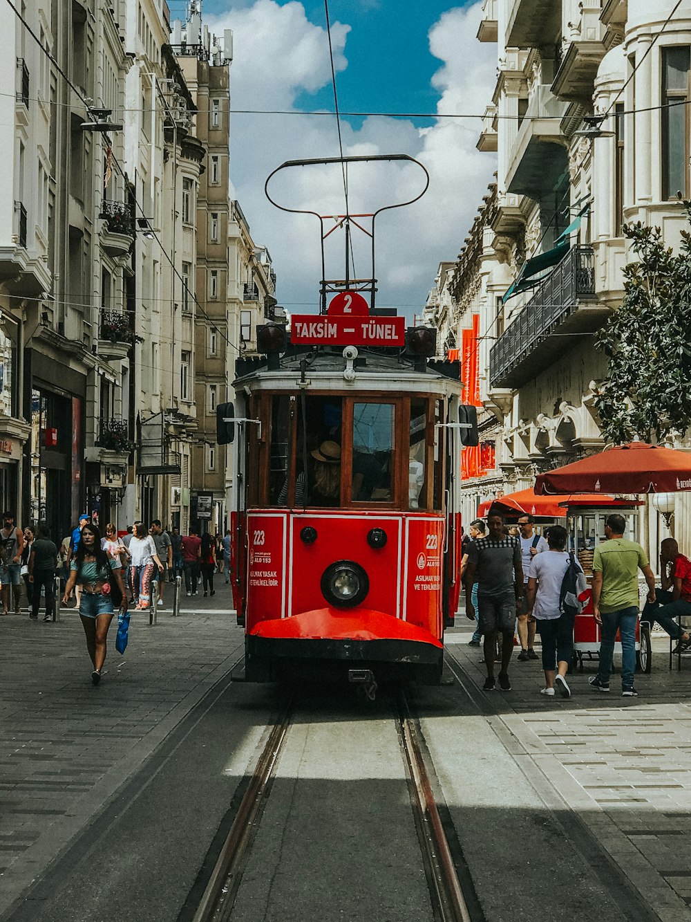 red tram on the street during daytime