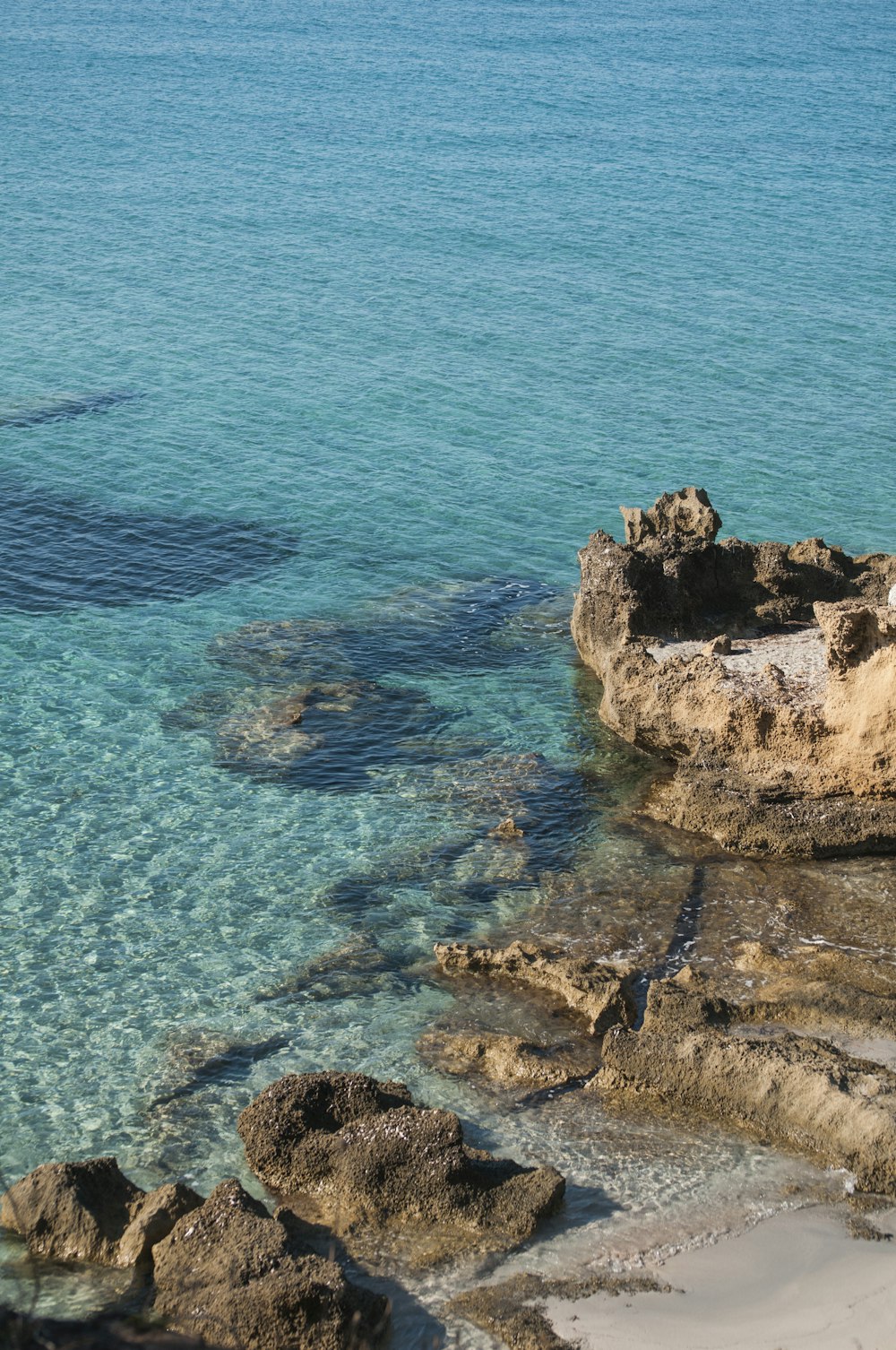 brown rock formation on blue sea during daytime