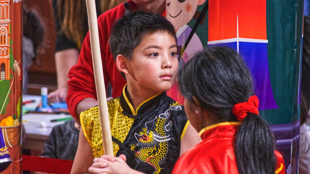 boy in red shirt holding stick