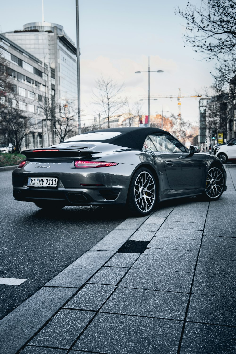 Dark gray Porsche 911 driving around a corner