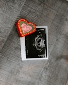 red and white heart print card on brown textile