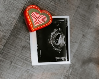 red and white heart print card on brown textile