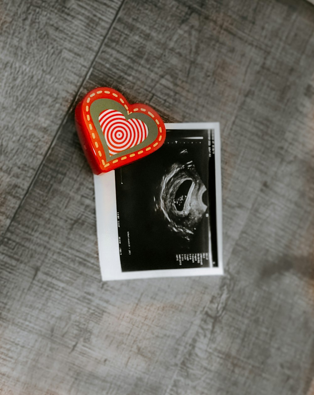 red and white heart print card on brown textile