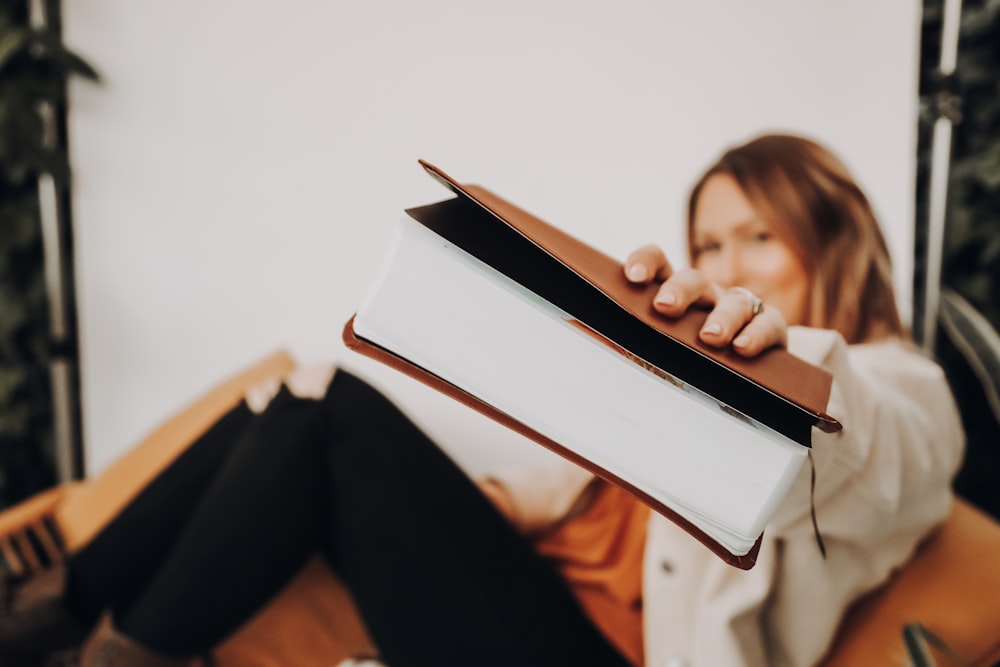 woman in black pants reading book