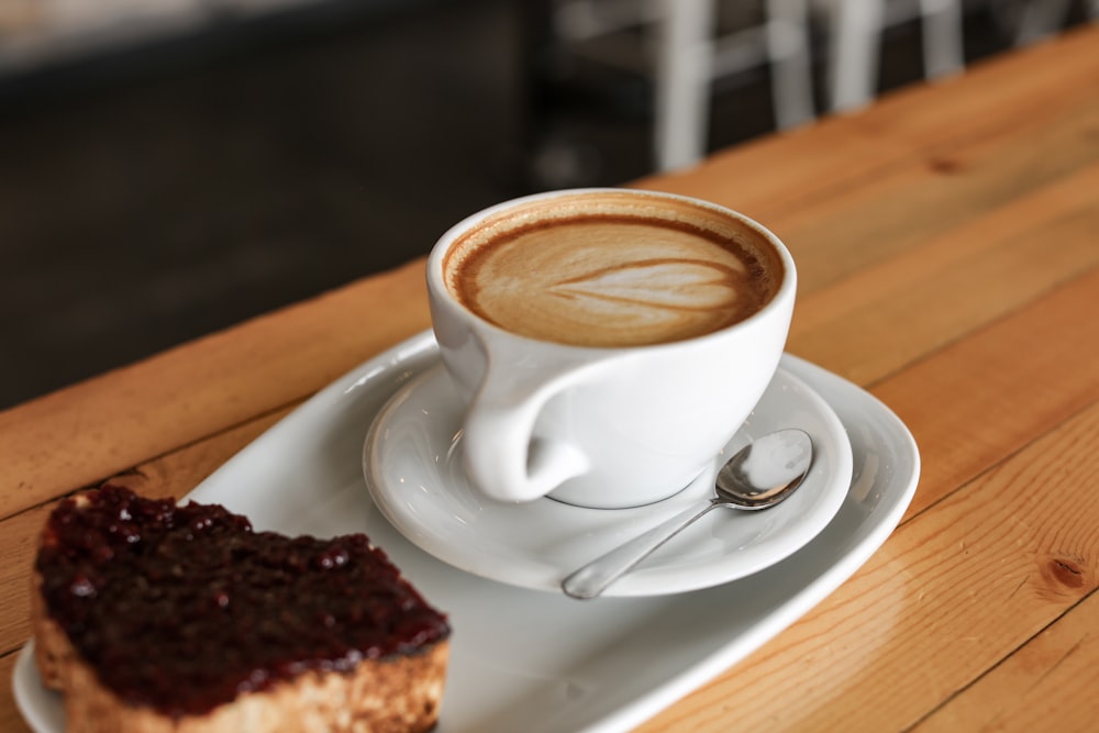 white ceramic cup with saucer on brown wooden table