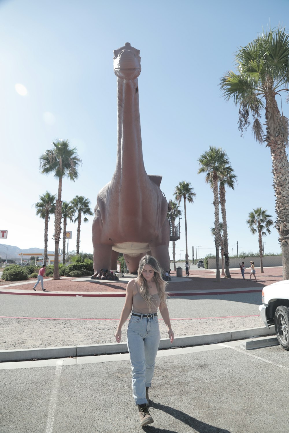 woman in blue denim shorts standing near brown statue during daytime