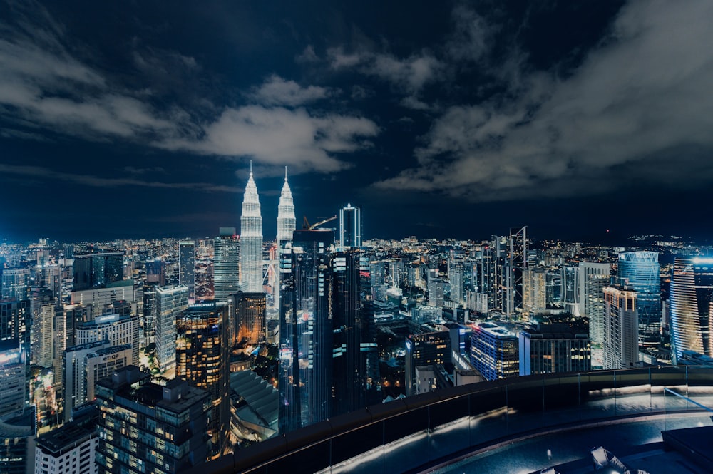 city skyline under gray cloudy sky during night time