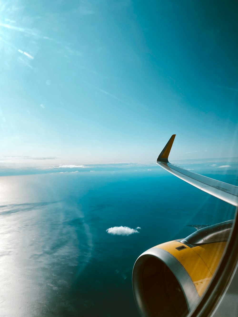 airplane window view of blue sky during daytime