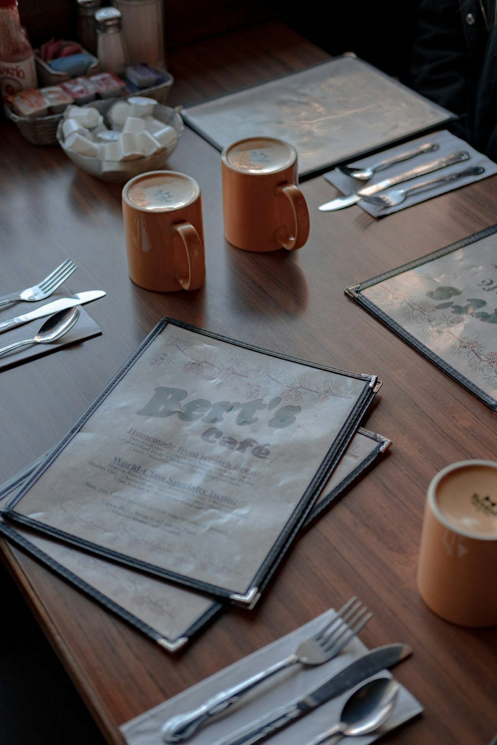 white ceramic mug beside white printer paper on brown wooden table