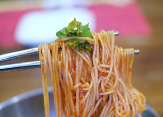 pasta with green leaf on stainless steel bowl