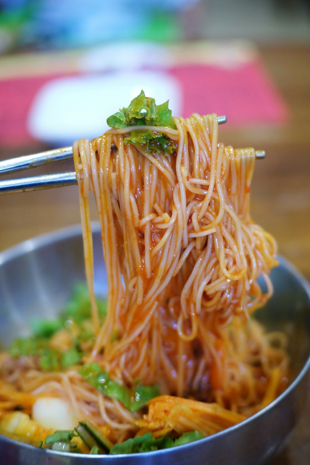 pasta con hoja verde en bol de acero inoxidable